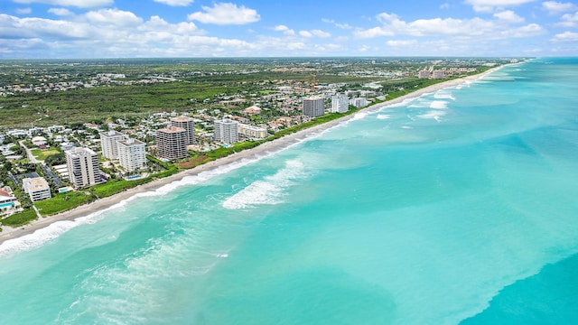 birds eye view of property with a water view and a beach view