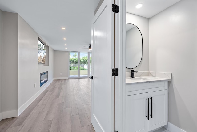 bathroom with expansive windows, vanity, and hardwood / wood-style floors