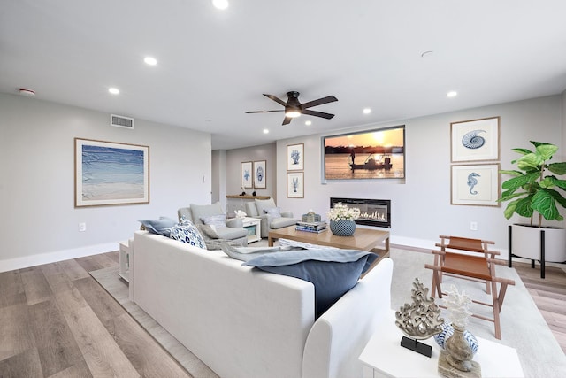 living room with ceiling fan and light hardwood / wood-style flooring