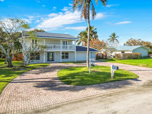 view of front of house with a balcony and a front yard