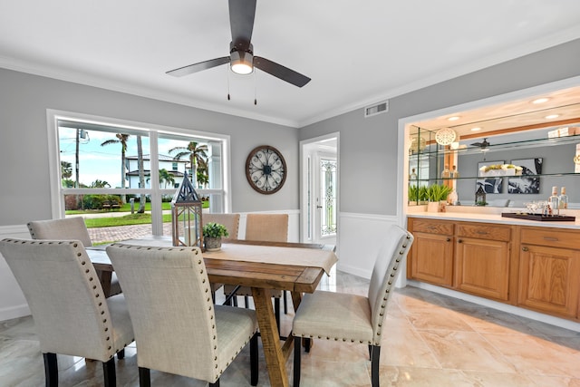 dining area featuring crown molding and ceiling fan