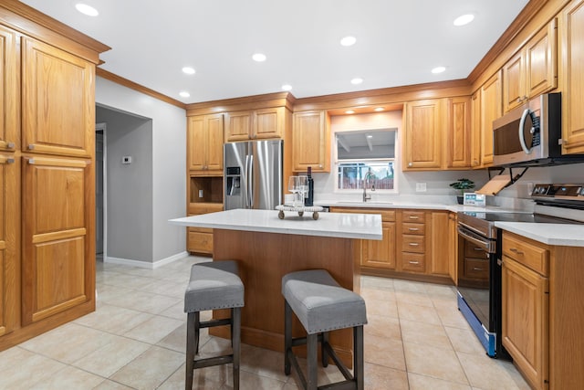 kitchen featuring sink, light tile patterned floors, a breakfast bar area, stainless steel appliances, and a kitchen island