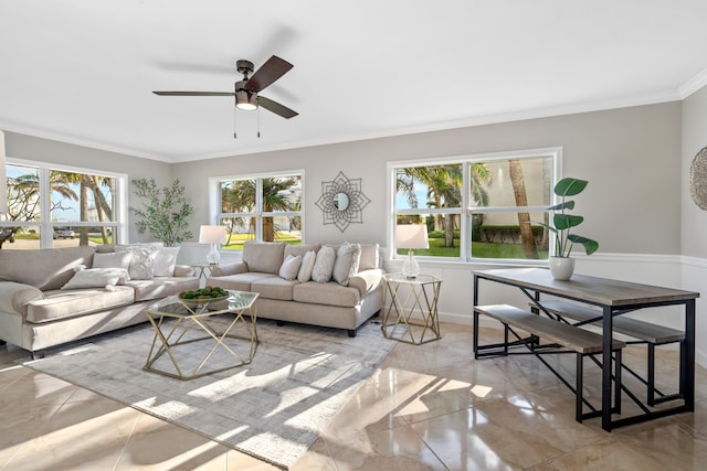 living room featuring ceiling fan, ornamental molding, and a healthy amount of sunlight