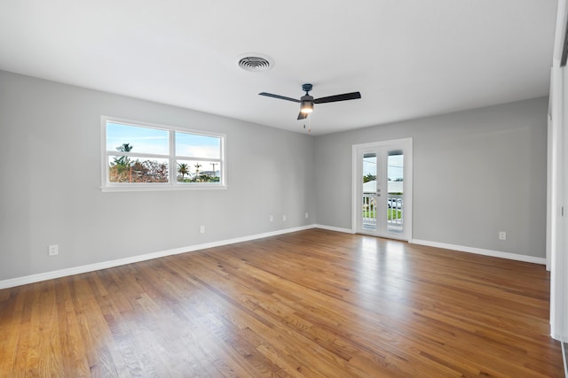 empty room with hardwood / wood-style flooring, ceiling fan, and french doors