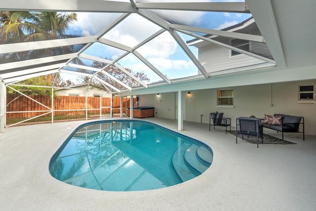 view of swimming pool featuring a hot tub, a lanai, and a patio area