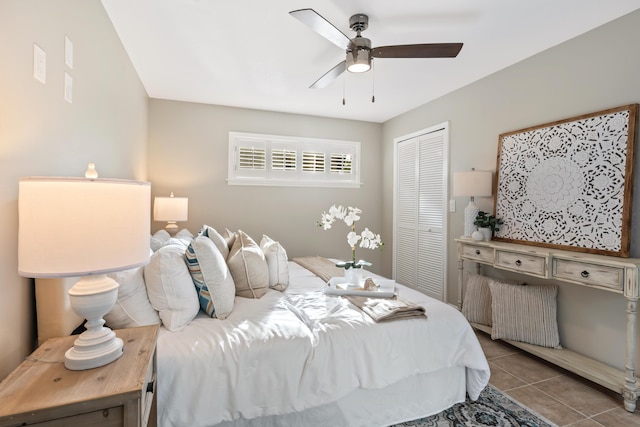 bedroom featuring light tile patterned flooring, ceiling fan, and a closet