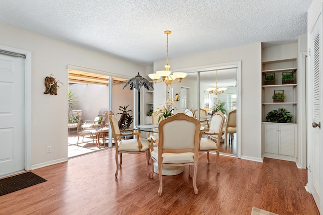 dining space featuring hardwood / wood-style floors, a notable chandelier, and a textured ceiling