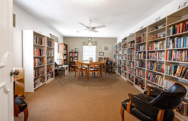 sitting room with a textured ceiling, ceiling fan, and carpet