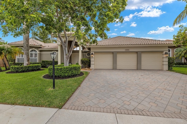 mediterranean / spanish-style home featuring a garage and a front yard