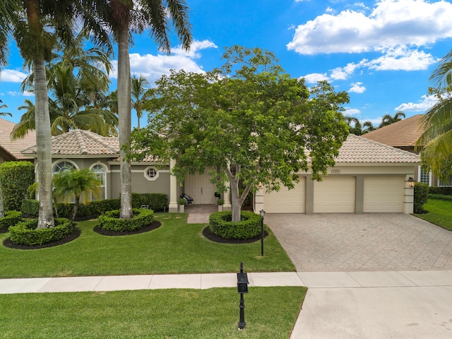 mediterranean / spanish-style house featuring a garage and a front yard