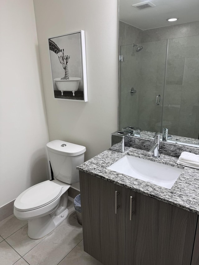 bathroom with vanity, tile patterned flooring, toilet, and walk in shower