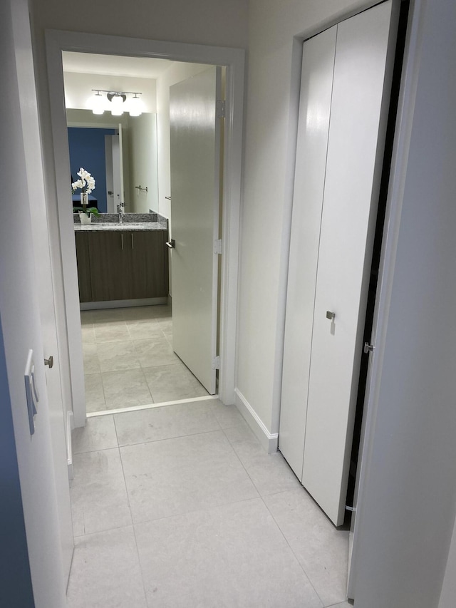 hall with sink and light tile patterned floors