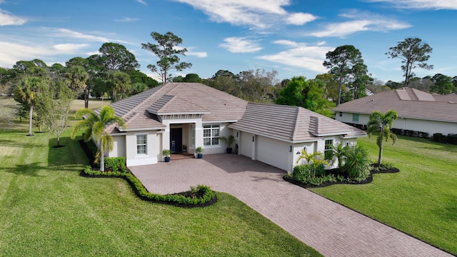 ranch-style home featuring a garage and a front lawn