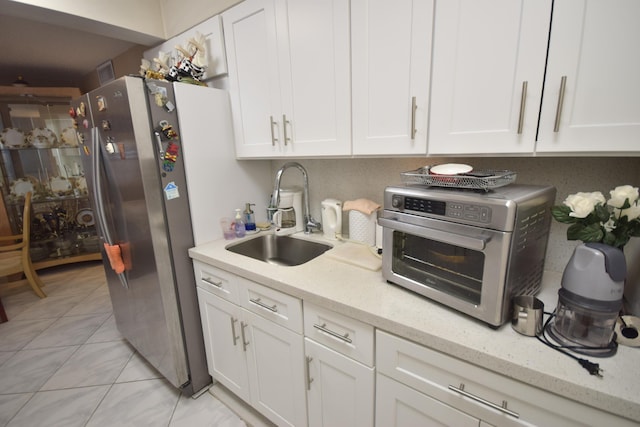 kitchen featuring white cabinetry, sink, and light stone counters