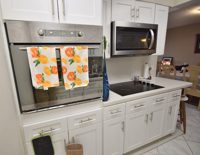 kitchen featuring stainless steel appliances and white cabinets