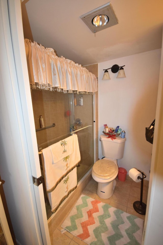 bathroom featuring tile patterned flooring, an enclosed shower, and toilet