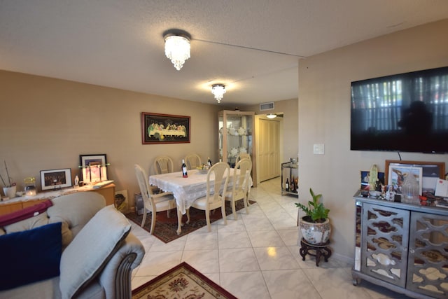 tiled dining room featuring a textured ceiling