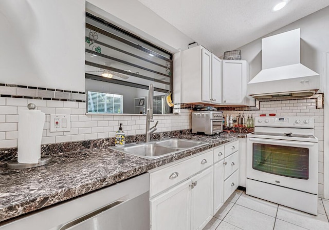 kitchen featuring premium range hood, light tile patterned flooring, white range with electric stovetop, white cabinetry, and dark stone counters