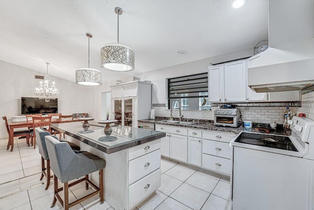 kitchen with white electric range oven, sink, hanging light fixtures, white cabinets, and backsplash