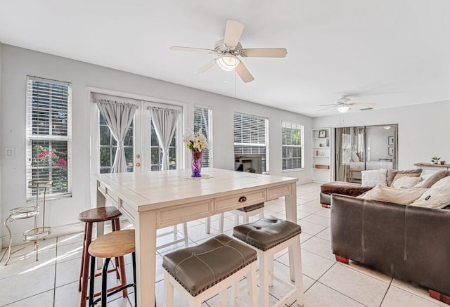 kitchen featuring french doors, a breakfast bar, ceiling fan, and light tile patterned flooring