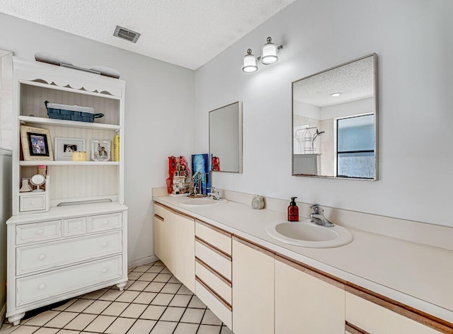 bathroom featuring vanity, tile patterned flooring, a textured ceiling, and walk in shower