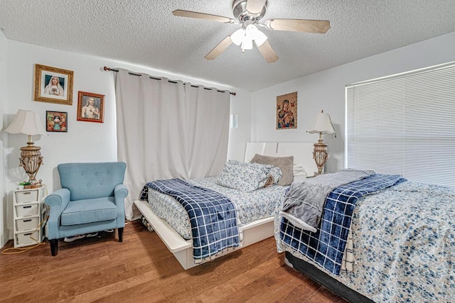 bedroom featuring hardwood / wood-style flooring, ceiling fan, and a textured ceiling