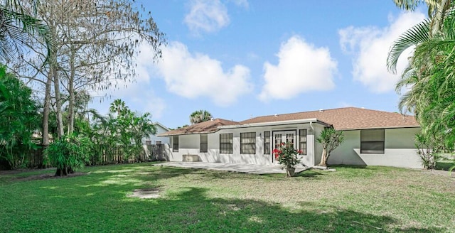 rear view of property featuring a yard and a patio