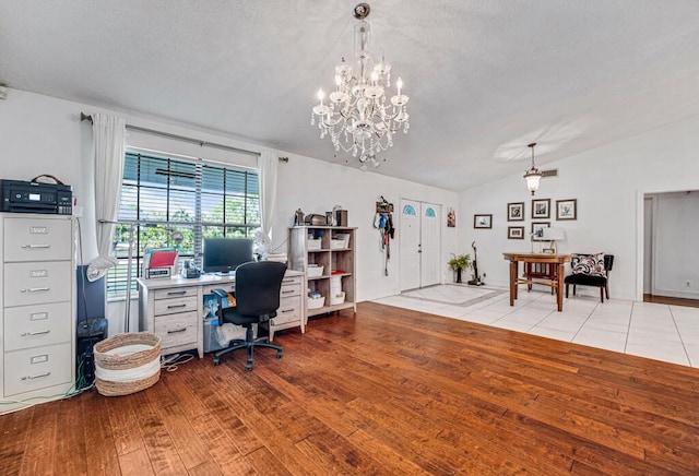 office area featuring lofted ceiling, light hardwood / wood-style flooring, and a textured ceiling