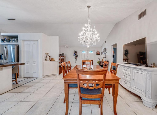 tiled dining area featuring lofted ceiling and an inviting chandelier