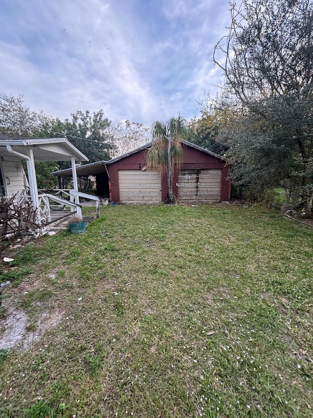 view of yard featuring a garage and an outbuilding