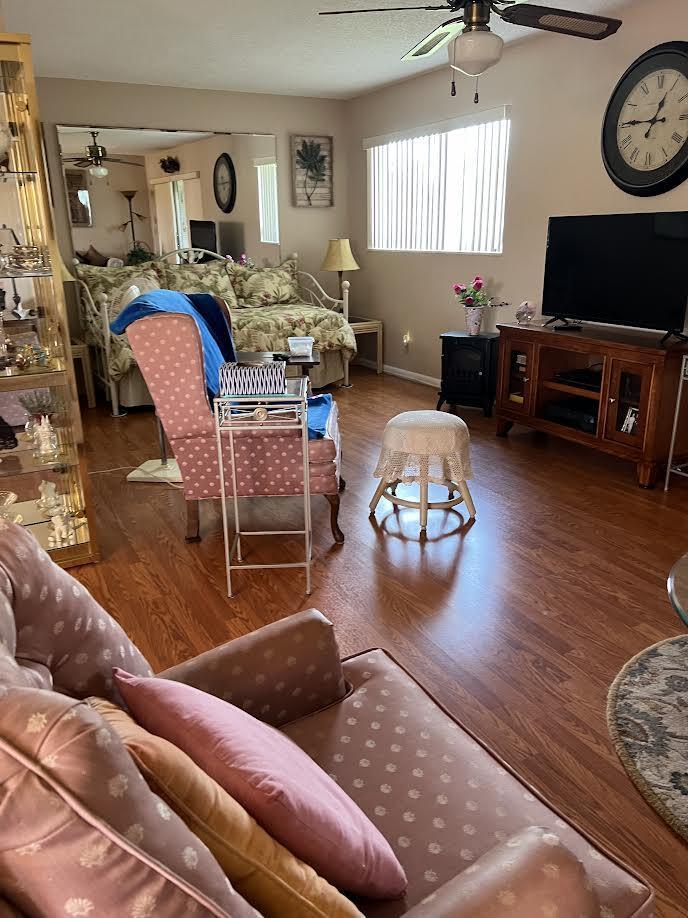 living room featuring hardwood / wood-style floors and ceiling fan