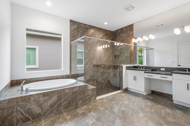 full bathroom featuring vanity, a stall shower, a bath, and visible vents