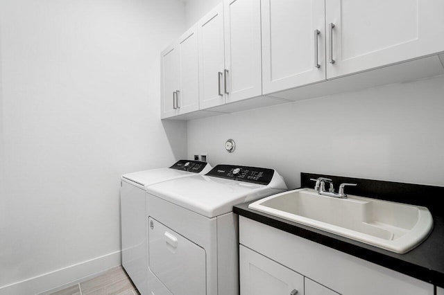 laundry area featuring cabinets, separate washer and dryer, and sink