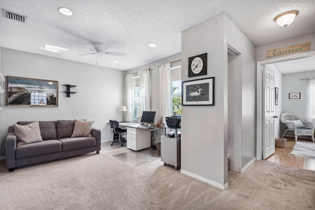 carpeted office with ceiling fan and a textured ceiling