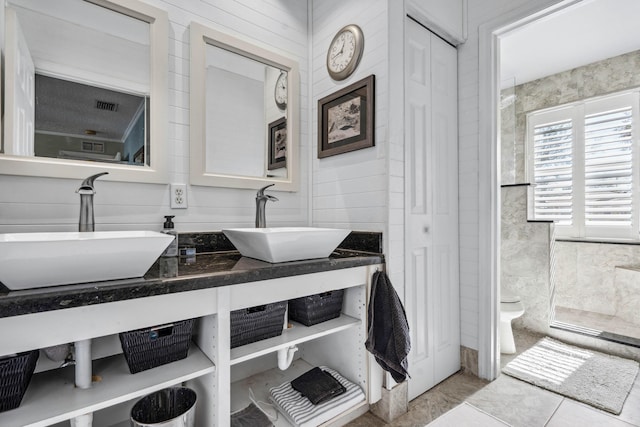 bathroom with tile walls, vanity, and toilet