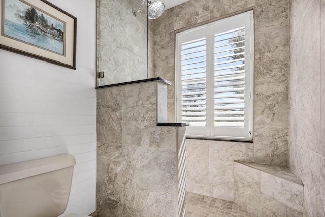 bathroom featuring toilet and a shower with shower door