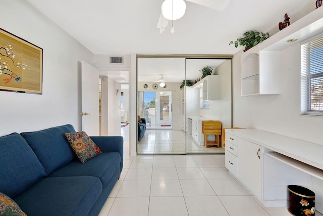 tiled living room featuring a healthy amount of sunlight and ceiling fan