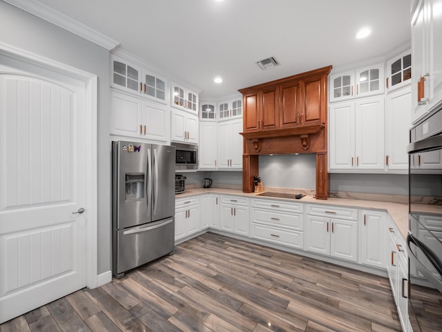 kitchen featuring dark wood-type flooring, ornamental molding, white cabinets, and appliances with stainless steel finishes