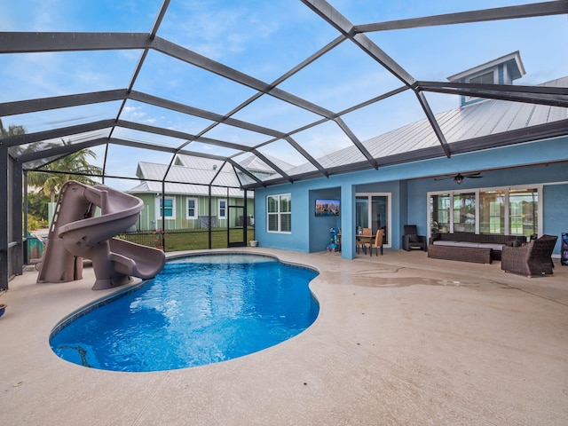 view of pool with a lanai, ceiling fan, a water slide, outdoor lounge area, and a patio