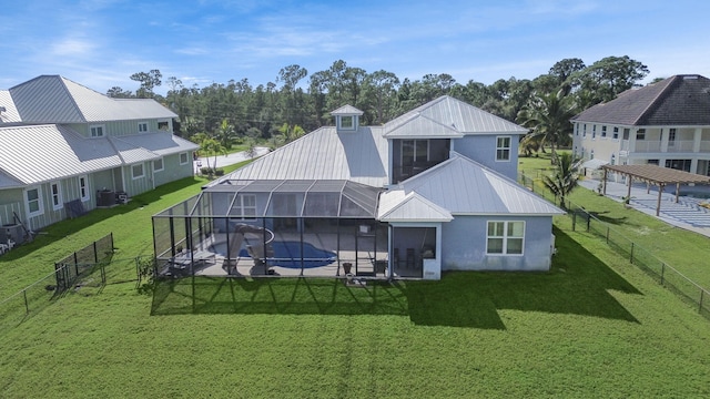 rear view of house featuring a fenced in pool, a lanai, and a yard