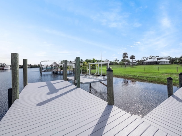 dock area featuring a water view and a lawn