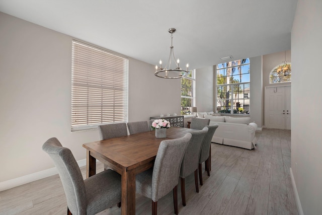 dining space with an inviting chandelier and light hardwood / wood-style floors