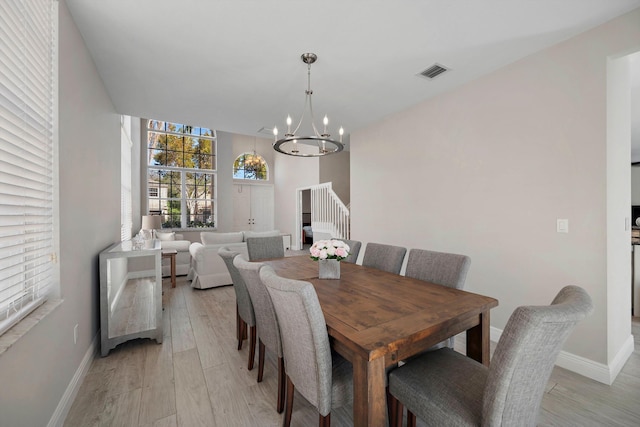 dining room featuring an inviting chandelier and light hardwood / wood-style flooring