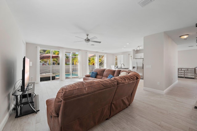 living room featuring light hardwood / wood-style flooring and ceiling fan