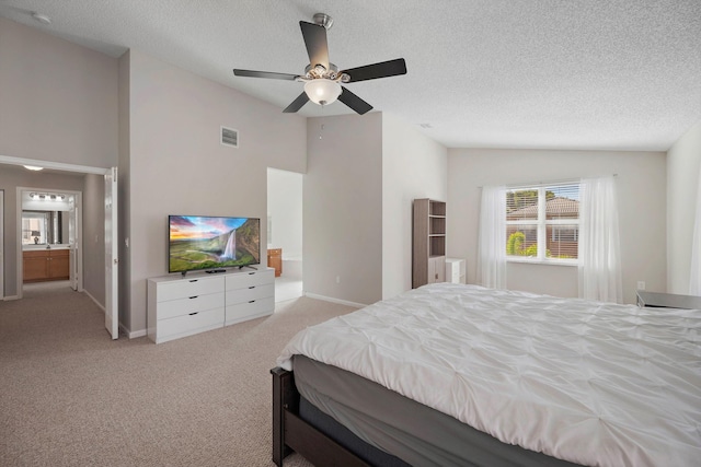 carpeted bedroom with lofted ceiling, ceiling fan, ensuite bath, and a textured ceiling