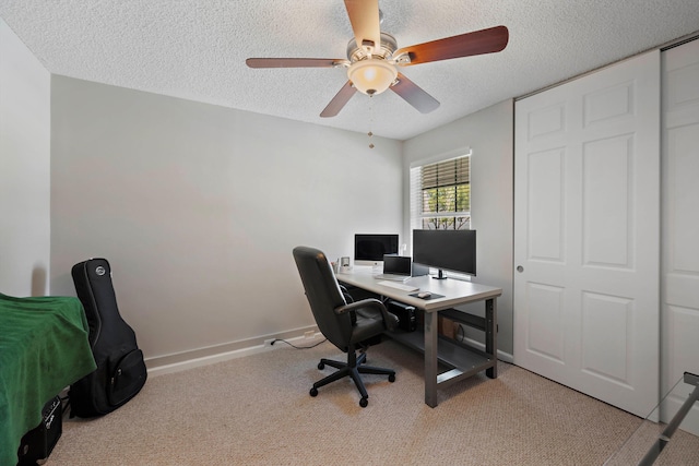 carpeted office space with ceiling fan and a textured ceiling