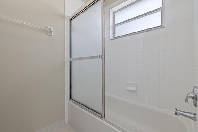 bathroom with shower / bath combination with glass door