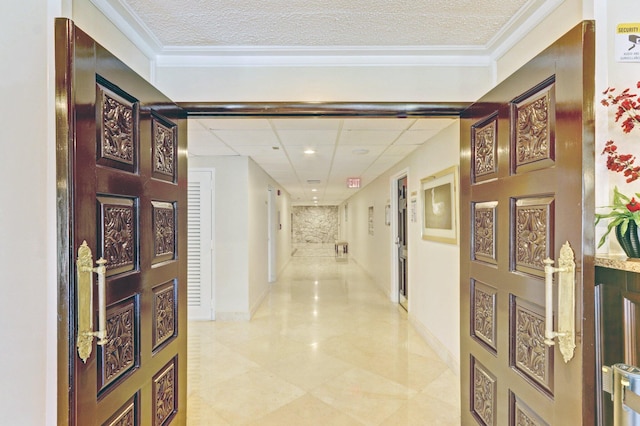 hallway featuring crown molding, a paneled ceiling, and a textured ceiling