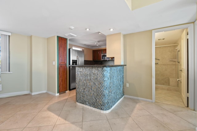 kitchen with light tile patterned flooring, ceiling fan, appliances with stainless steel finishes, and kitchen peninsula