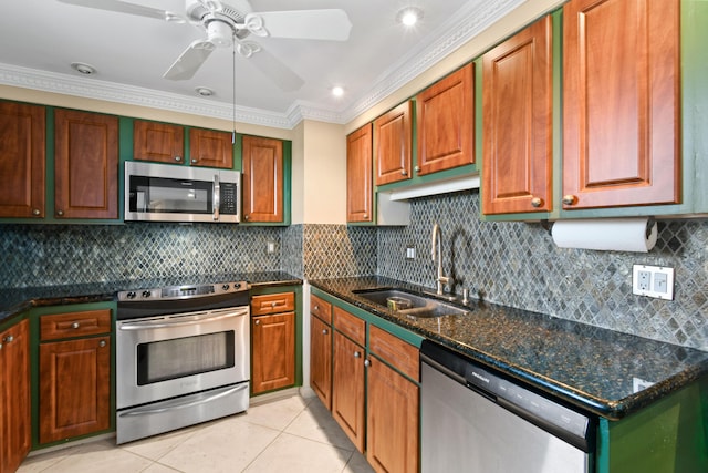 kitchen featuring appliances with stainless steel finishes, sink, dark stone countertops, decorative backsplash, and light tile patterned floors